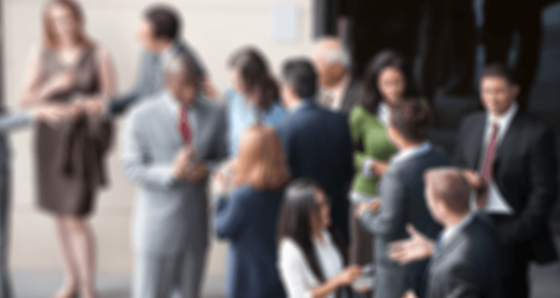 Blurry image of various groups of people talking