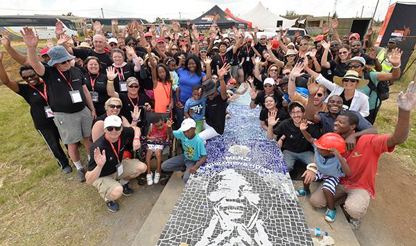 Group shot of people next to a Nelson Mandela mosaic